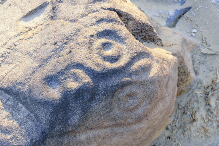 Sikachi-Alyan petroglyphs. Antique shamanic mask ( disguise ) carved in basalt stone on the Amur river bank. Оne of the seven wonders of the Khabarovsk territory. Far Est, Russia